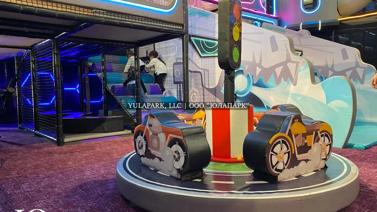 Прозрачный стеклянный мост с подсветкой и детская карусель для малышей в игровом парке для детей.