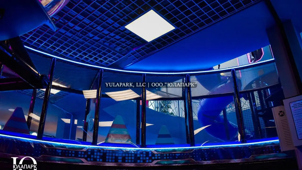 Вид на высокий многоэтажный лабиринт на прозрачный мост с неоновой подсветкой в детском активити-парке Движок.