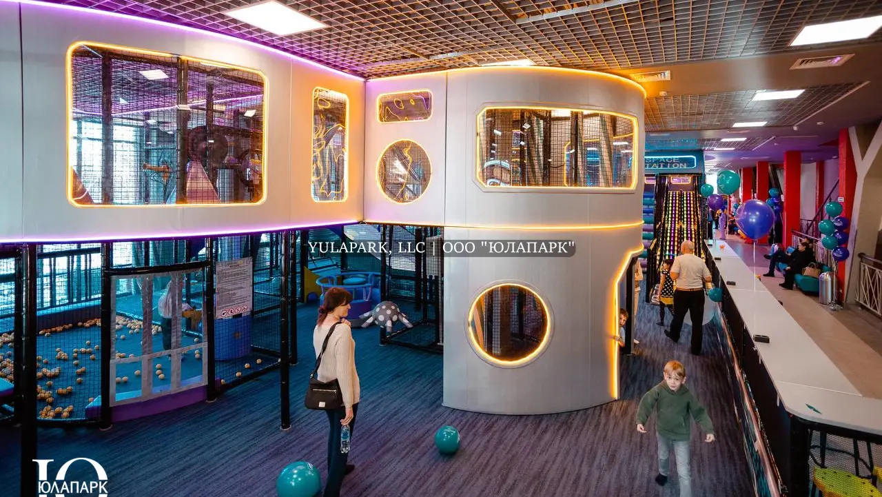 Вид на многоэтажный лабиринт в виде космического города с окнами в неоновой подсветке в детском парке Движок.