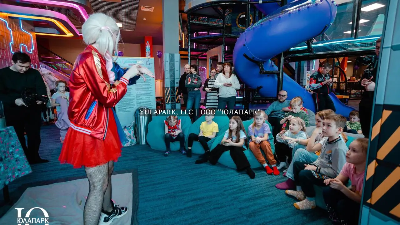 Детский аниматор в костюме и образе Харли Квин развлекает детей в детском парке в Движке в Омске.