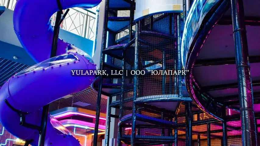 Высокая башня в виде космического корабля с неоновой подсветкой в детском активити-парке, с высокой закрученной пластиковой горкой в активити-парке Движок в Омске.