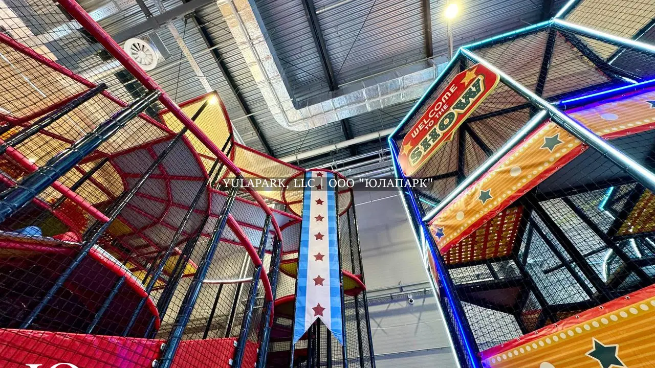 Многоэтажные башни в лабиринте с синей неоновой подсветкой в стиле цирка в детском парке Флик Фляк.