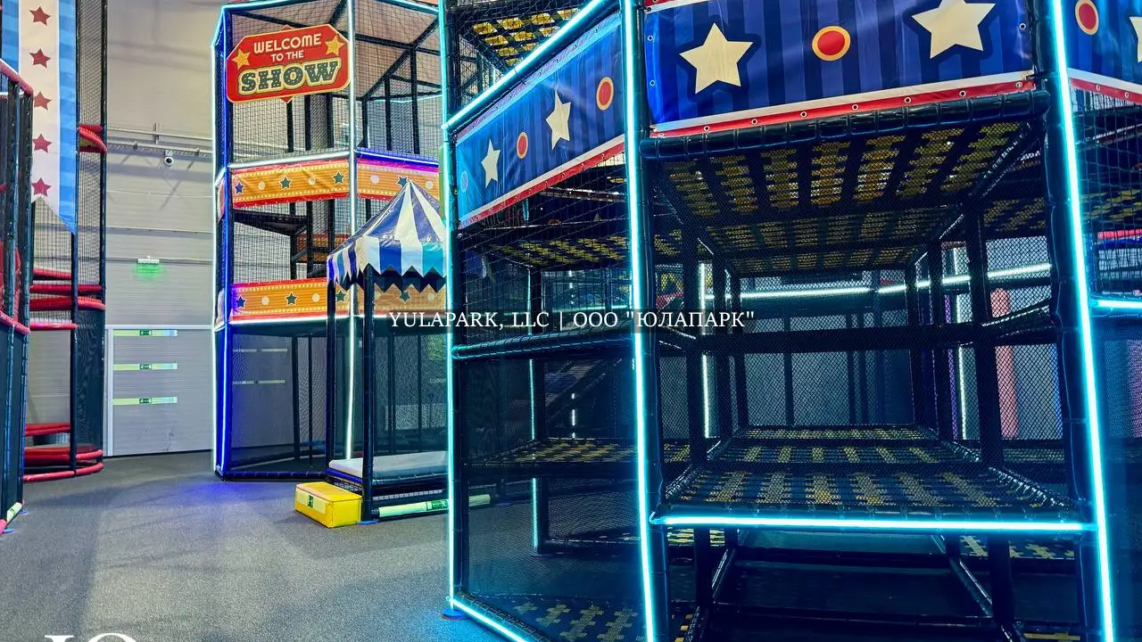 Многоэтажные башни в лабиринте с синей неоновой подсветкой в стиле цирка в детском парке Флик Фляк.
