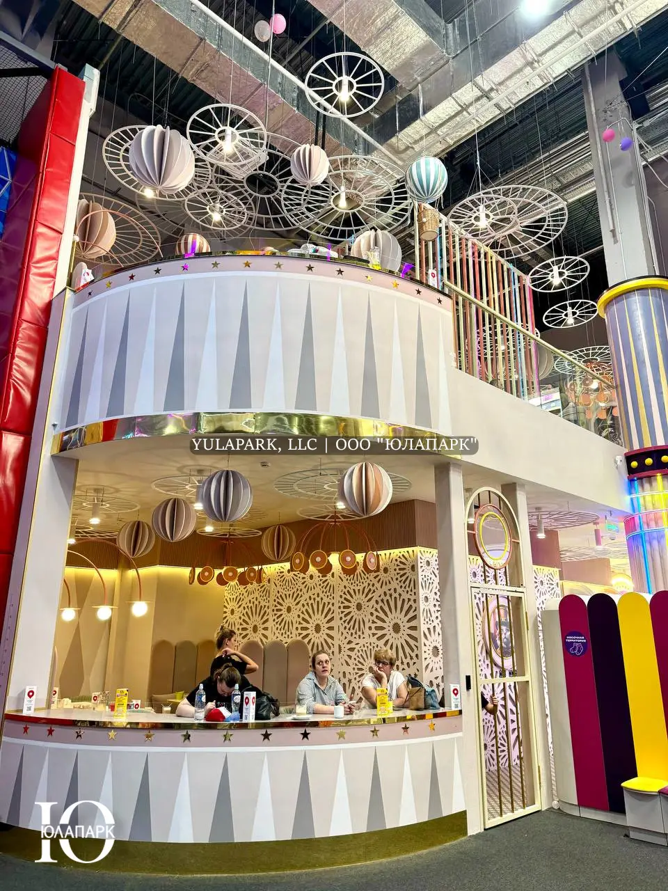 Двухэтажный ресторан в пастельных цветах в детском развлекательном центре Флик Фляк с баркатными барными стульями с видом на парк и скайрайдер.