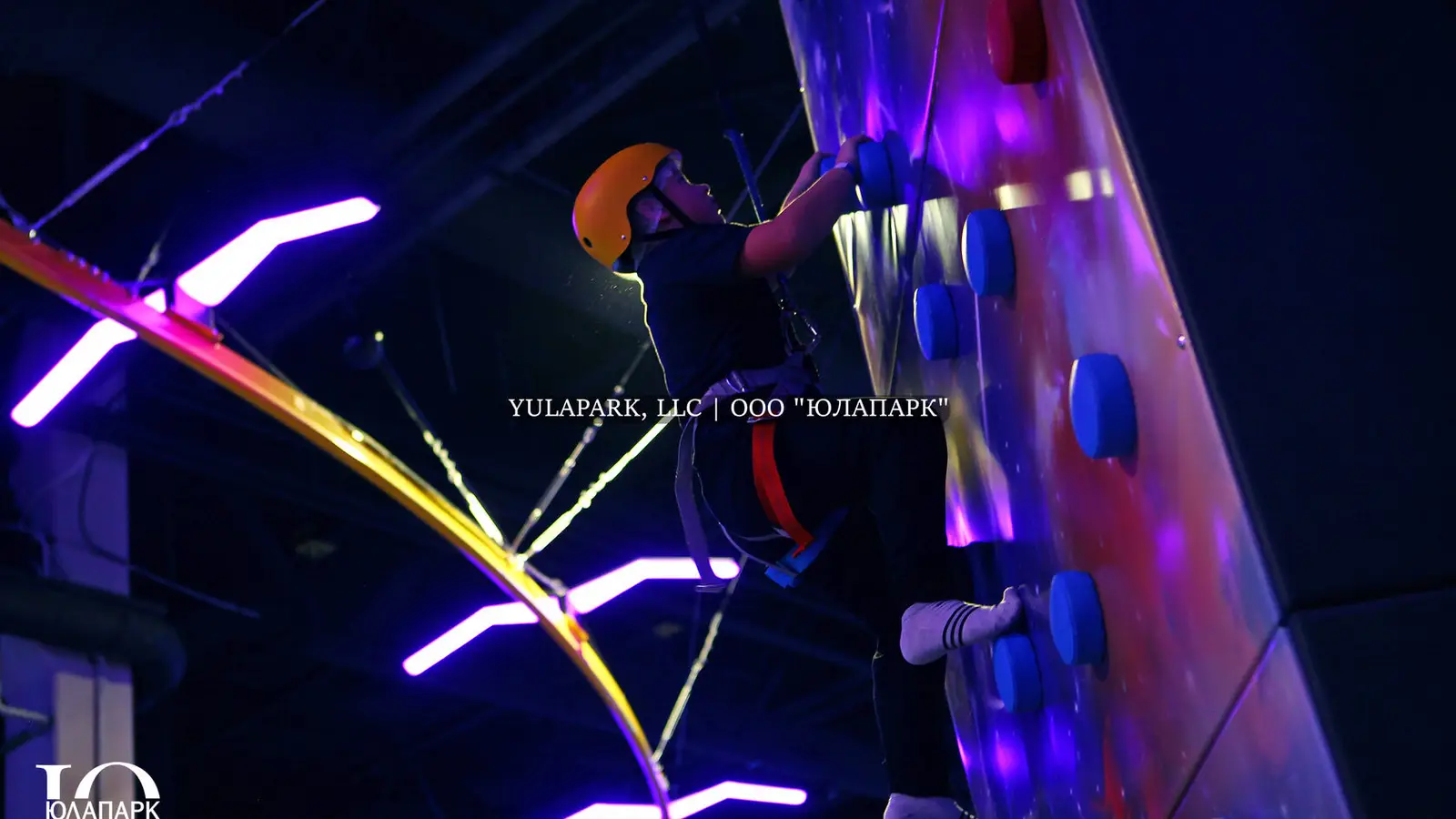 Children's playroom with a glowing skyrider, a climber, on which a child climbs in the style of the city of the future and with a lot of lighting