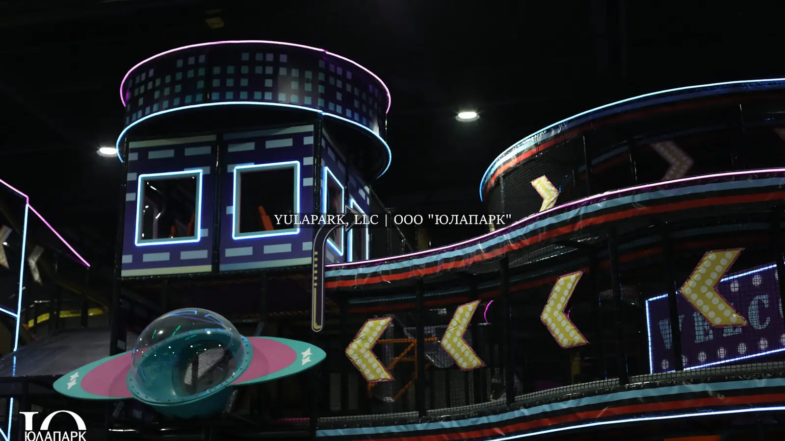 A family amusement park in Kaliningrad NEOPORT, a view of the labyrinths and challenges in the city of the future with neon lighting, as well as a transparent bridge with signs.