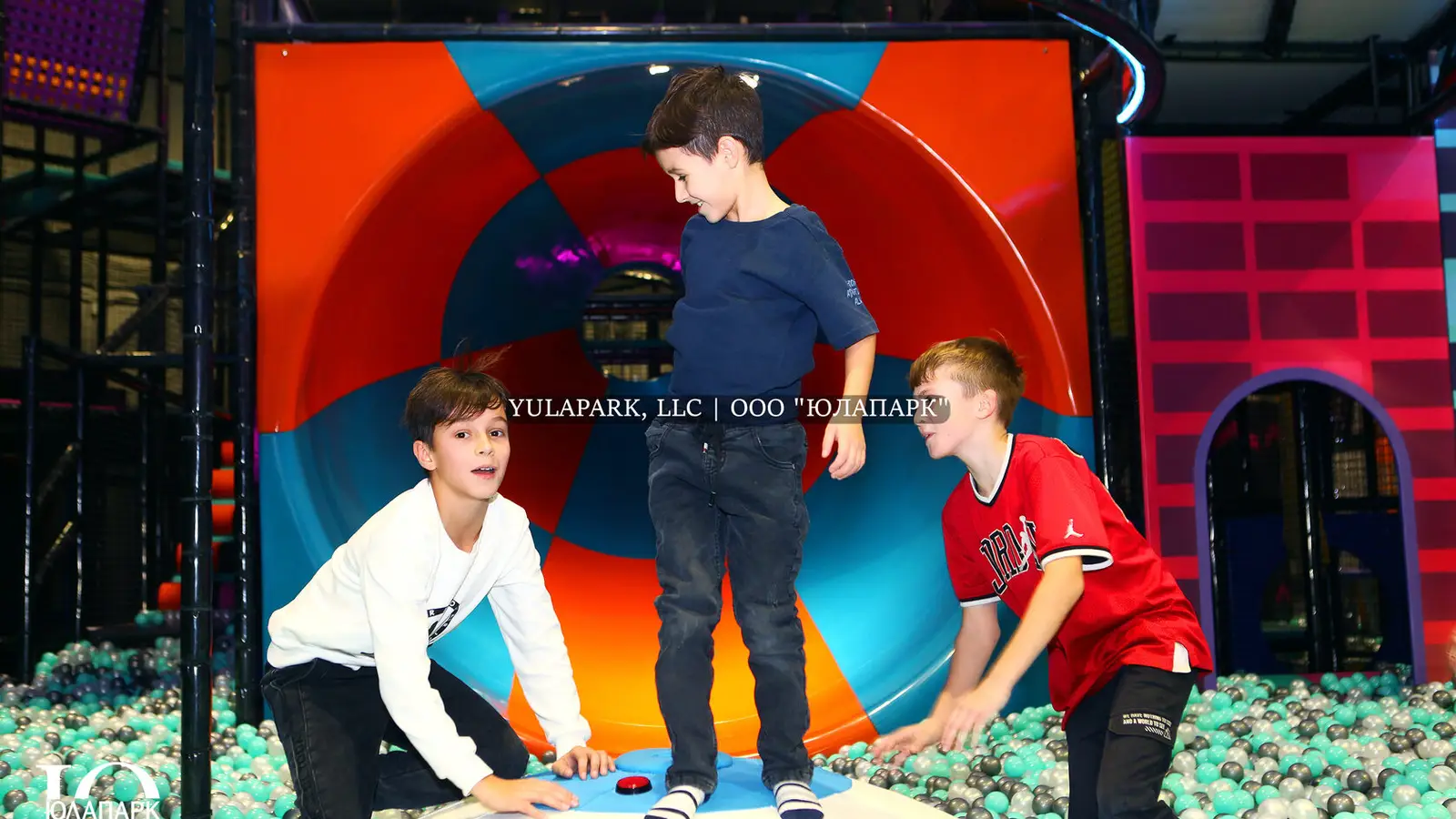 Slide funnel in the amusement park, ball pool and cheerful kids.