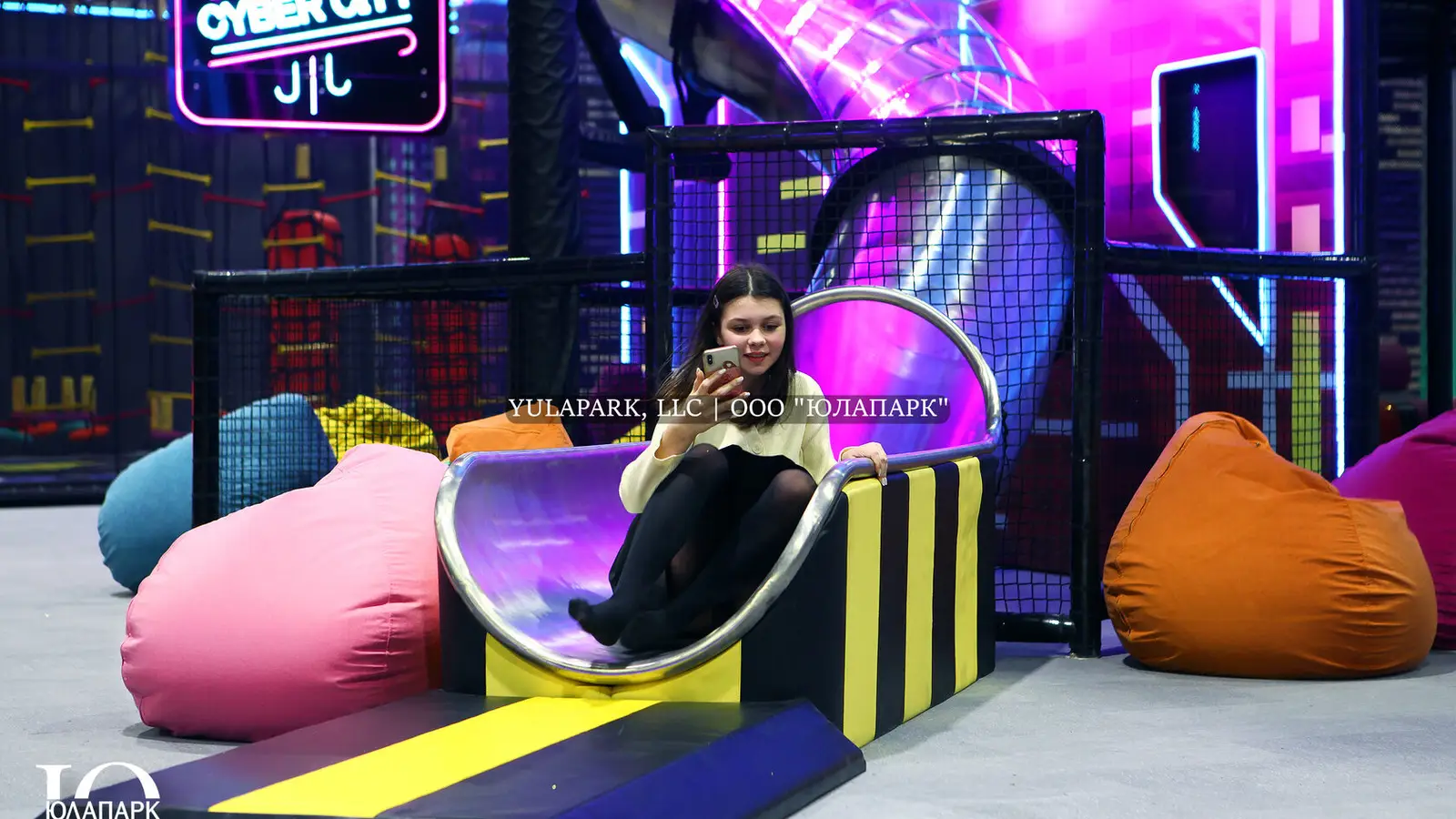 Children's amusement park, children's playroom with a restaurant in Kaliningrad. A steel slide with lighting in the city of the future with person.