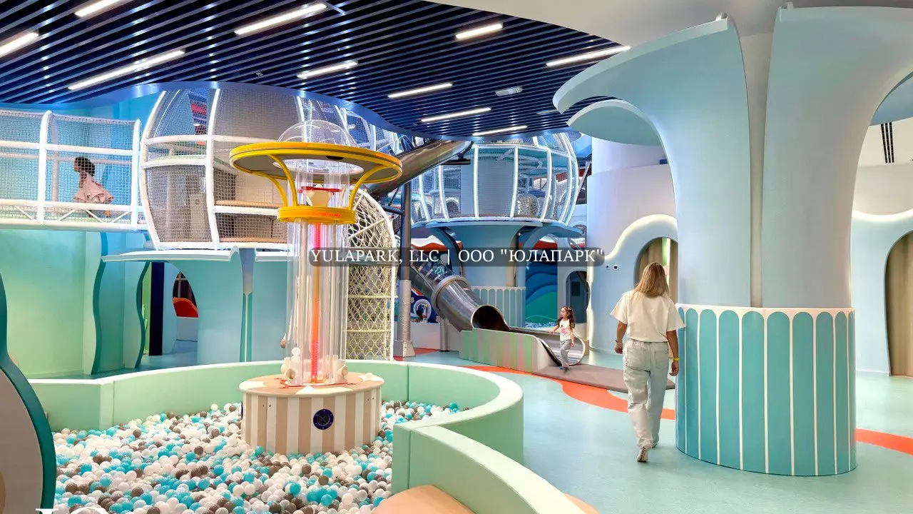 Сухой фонтан с шариками в сухом бассейне, лабиринт в виде кораллов и стальная светящаяся горка в детском парке развлечений в стиле подводного мира в Дубае