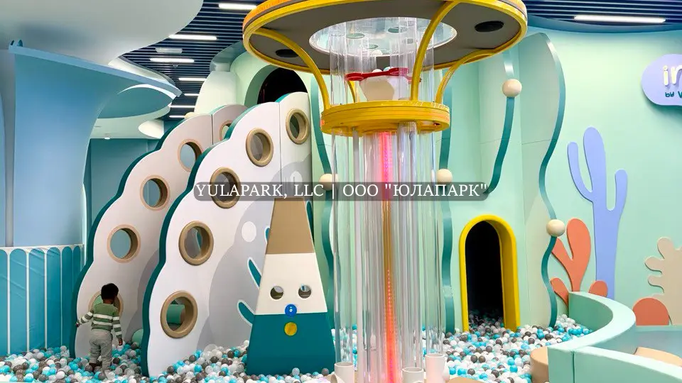 Сухой фонтан с шариками в сухом бассейне, лабиринт в виде кораллов и стальная светящаяся горка в детском парке развлечений в стиле подводного мира в Дубае