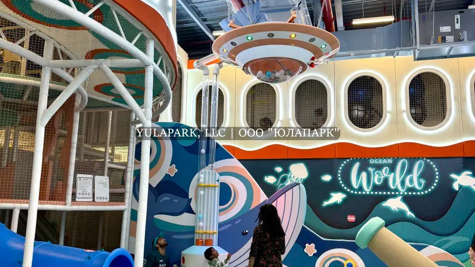 Игровая зона с большим сухим бассейном, разноцветными горками и лабиринтом в виде кораллов с неоновой подсветкой в Октопусе парке в Дубае