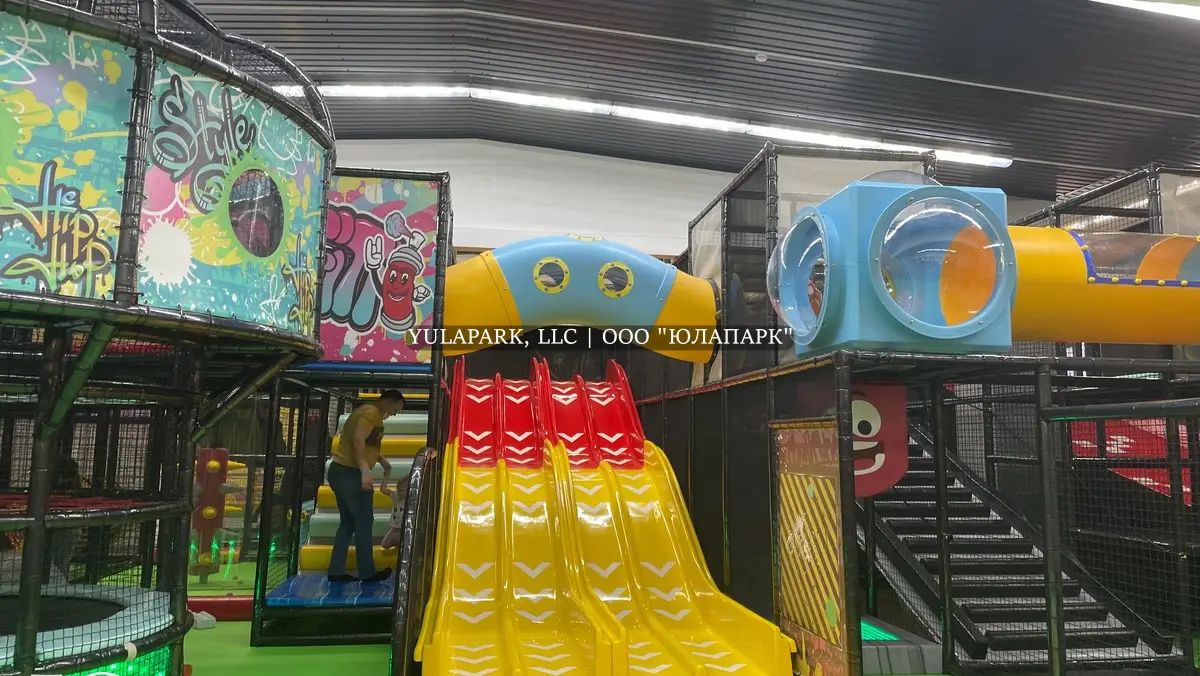 Детский парк развлечений в стиле граффити с различными пластиковыми горками.