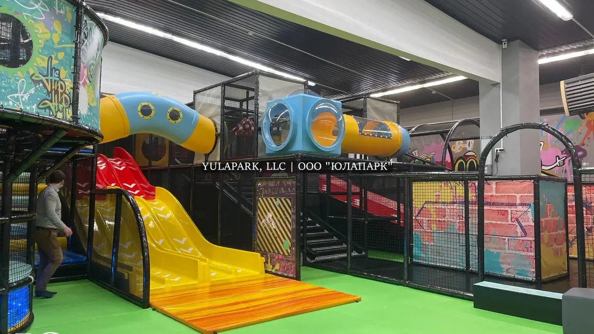 Детский парк развлечений в стиле граффити с различными пластиковыми горками.